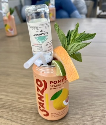 Party drink styled with fresh citrus, mint and a miniature tequila bottle